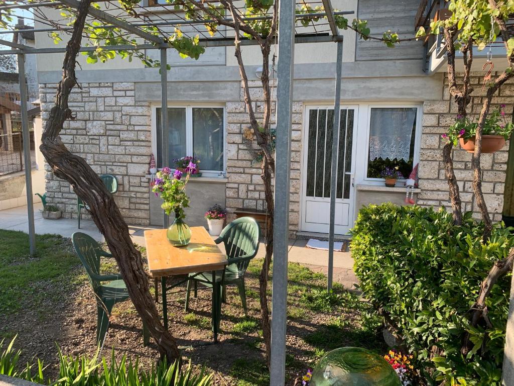 a table and chairs in a garden with a building at Appartamento Ape Verde in Piano dʼArta