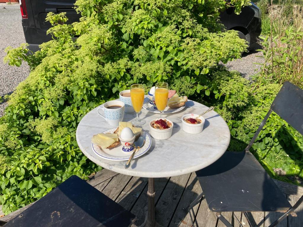 a table with food and two glasses of orange juice at Smedjan Bed and Breakfast in Varberg