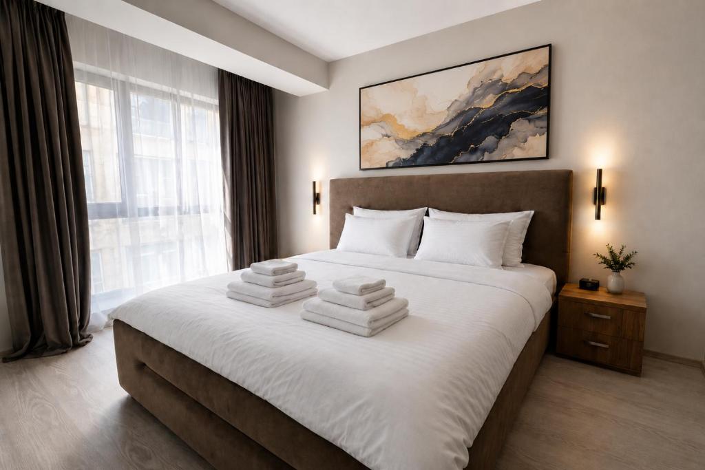a bedroom with a large bed with towels on it at Virello Aparthotel 4 SELF CHECK-IN #Otopeni #Airport #Therme #Bucharest in Otopeni