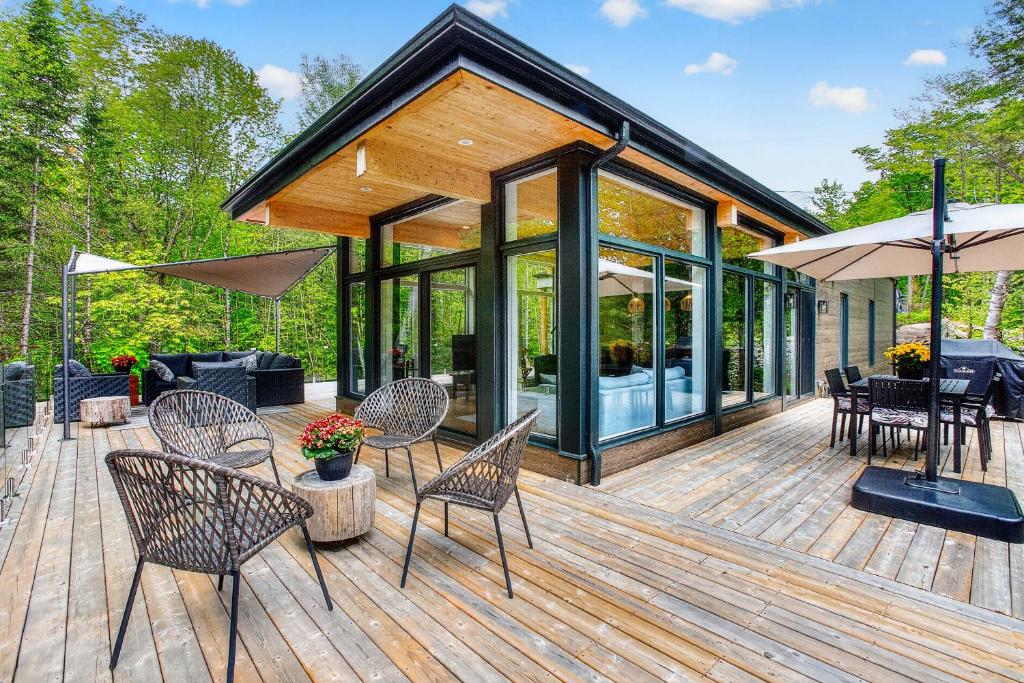 a wooden deck with chairs and tables at La Trêve Mont Tremblant in La Conception
