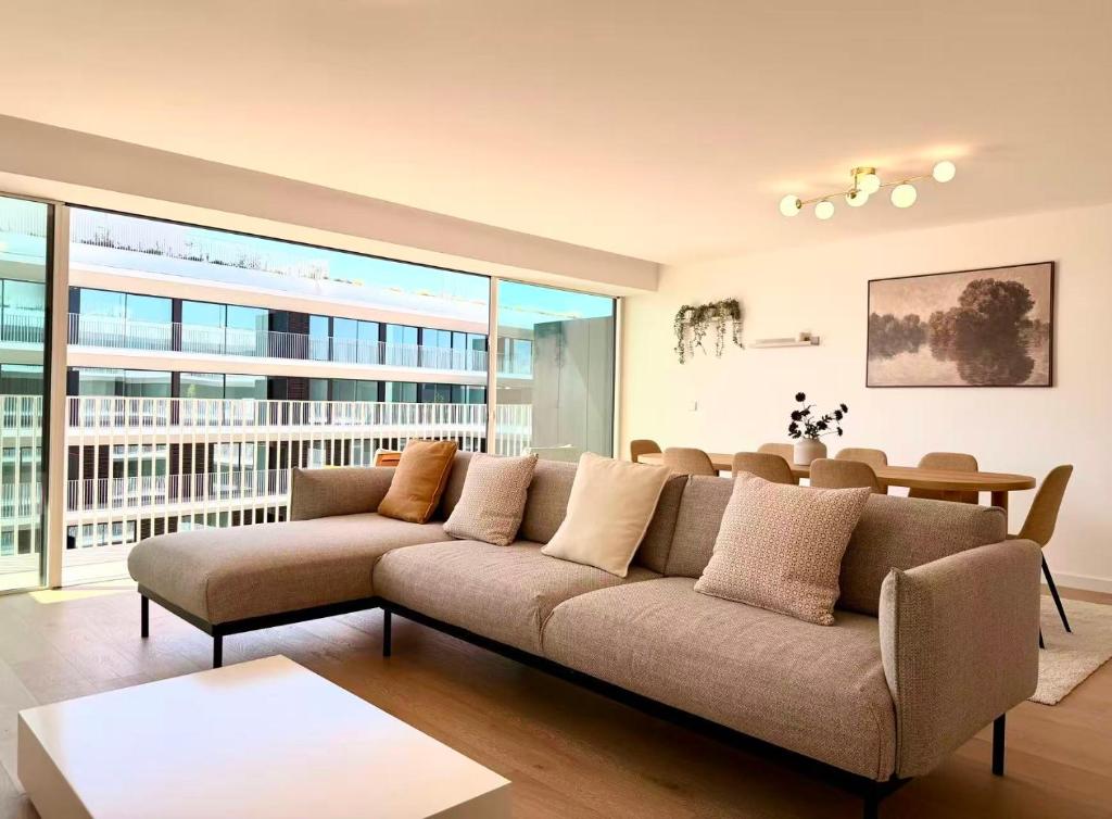 a living room with a couch and a large window at Nooba Barreiro Apartment in Barreiro