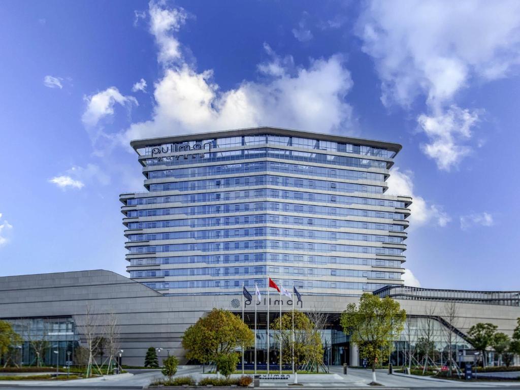 a building with a sign on the top of it at Pullman Suzhou Taicang in Taicang