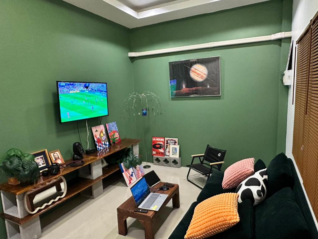 a living room with a couch and a tv at Krabi Buddy House in Ban Khlong Chi Lat