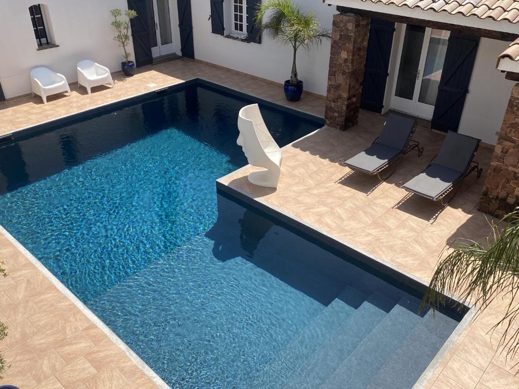 a pool with two chairs and a swimming pool at Le Patio Bleu in La Crau
