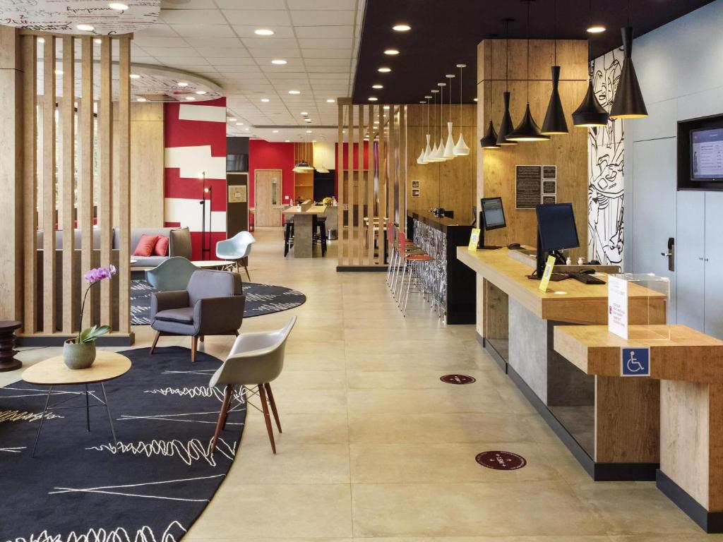 a lobby of a restaurant with chairs and a counter at Ibis Guaxupe in Guaxupé