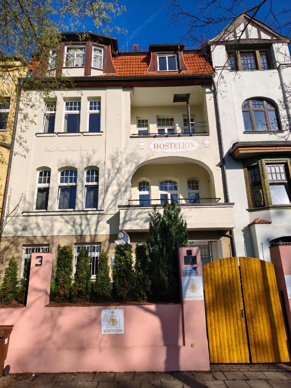 a large white building with a fence in front of it at Hostelion in Magdeburg