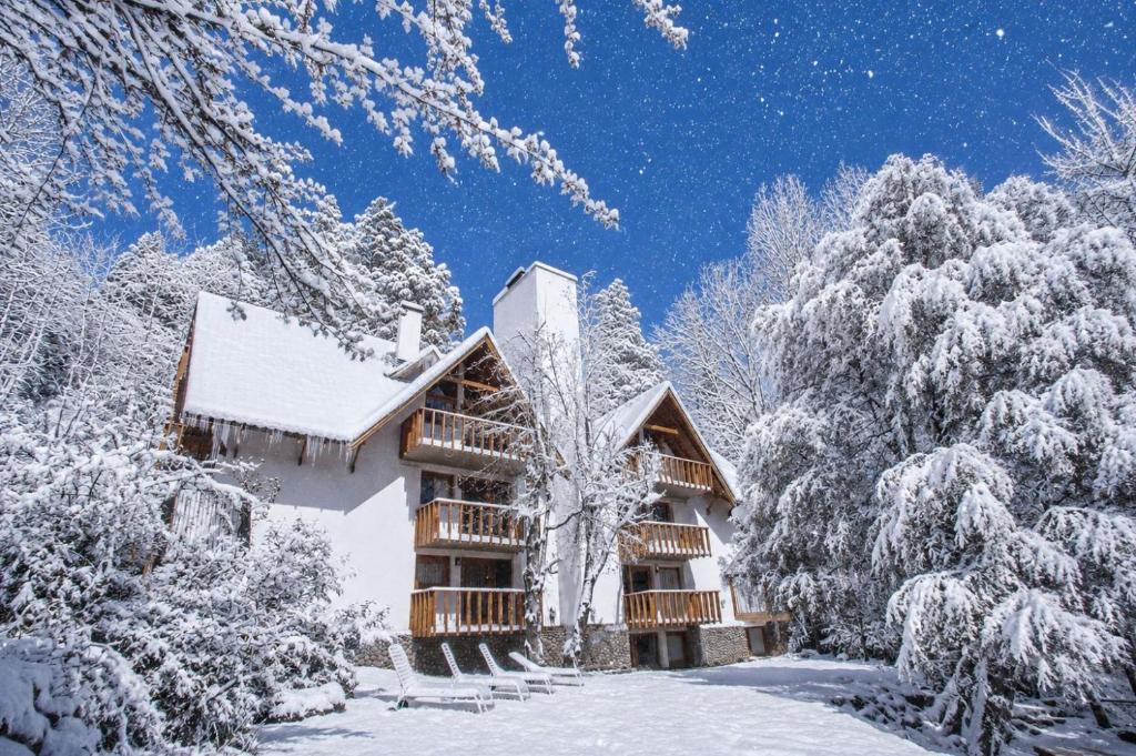 a cabin in the snow with snow covered trees at Cabañas Rucaleufu in San Martín de los Andes