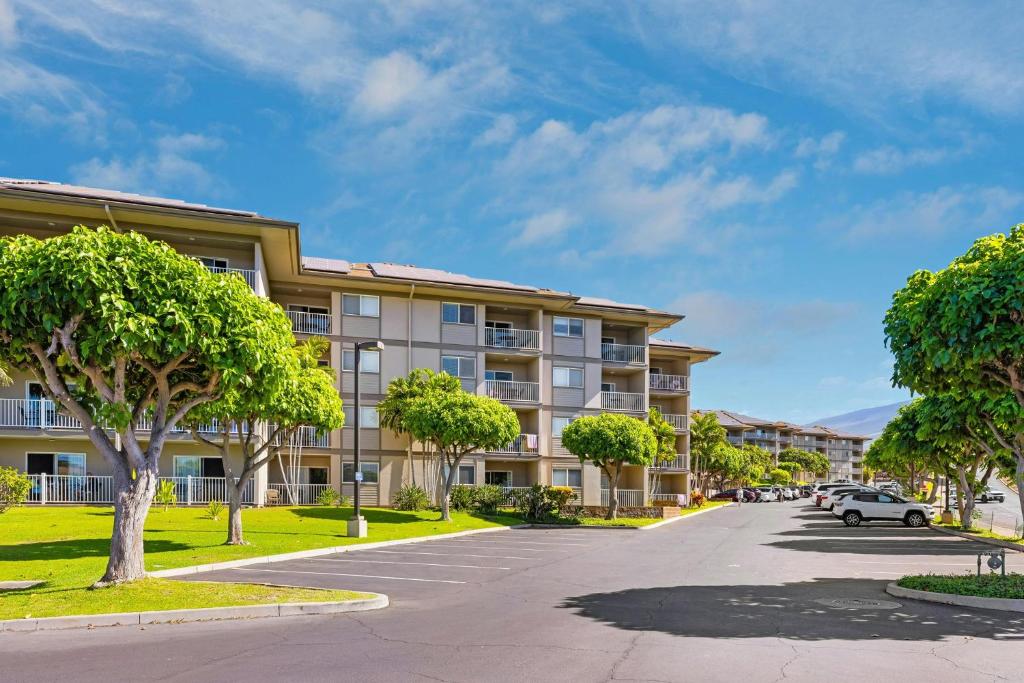 an apartment building with a car parked in the driveway at WorldMark Kihei in Kihei