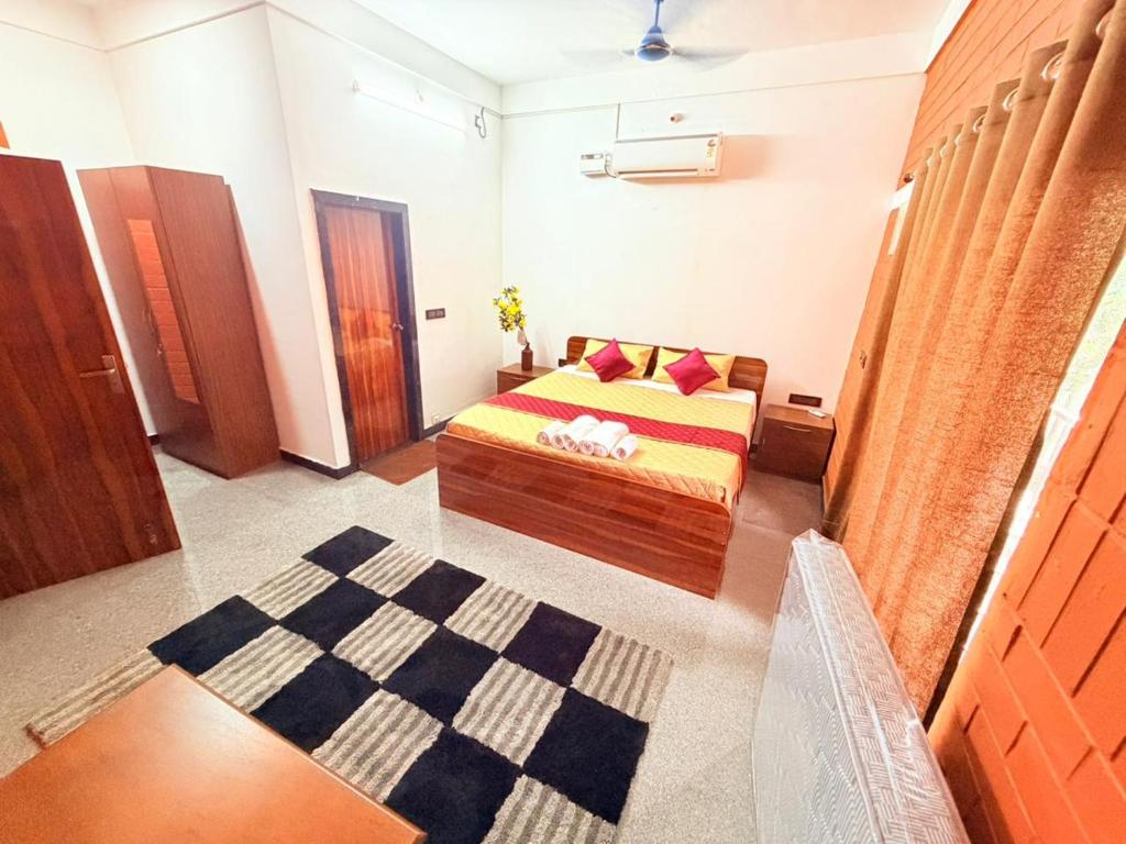 a small bedroom with a bed and a rug at JayKay Resort in Pūrnānkuppam