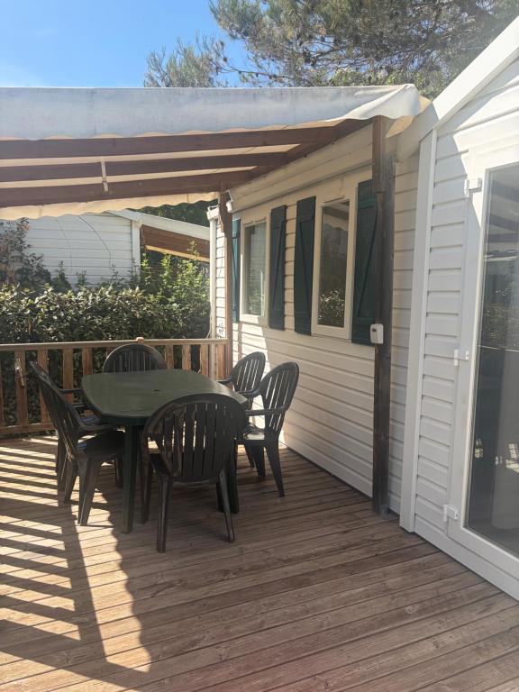 a patio with a table and chairs on a deck at camping des iscles 167 in La Roque-dʼAnthéron
