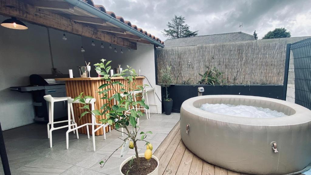 a bath tub sitting on a patio with a plant at Sabrina in Tarbes