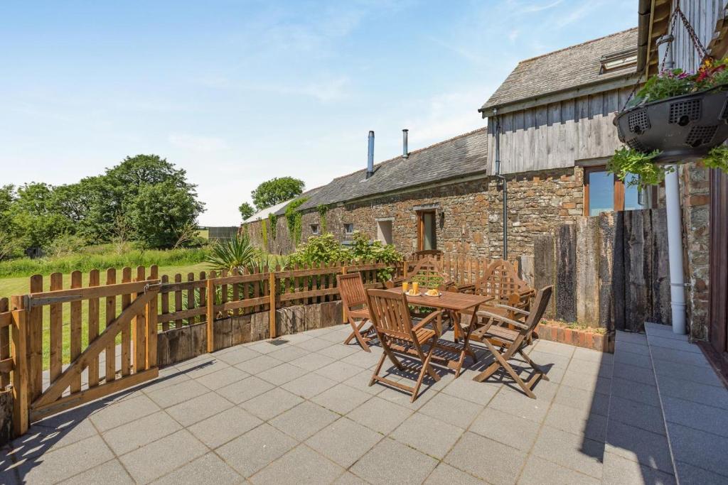 a patio with a wooden fence and a table and chairs at 3 Bed in Bideford oc-05171 in Woolfardisworthy