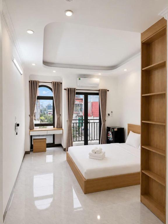a bedroom with a large bed and a balcony at Dreamora Serenity Hotel & Residence in Hanoi