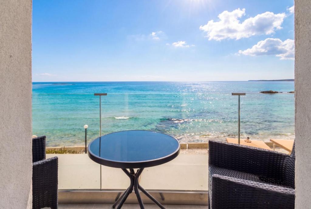 a table on a balcony with a view of the ocean at Julies Studios in Chania