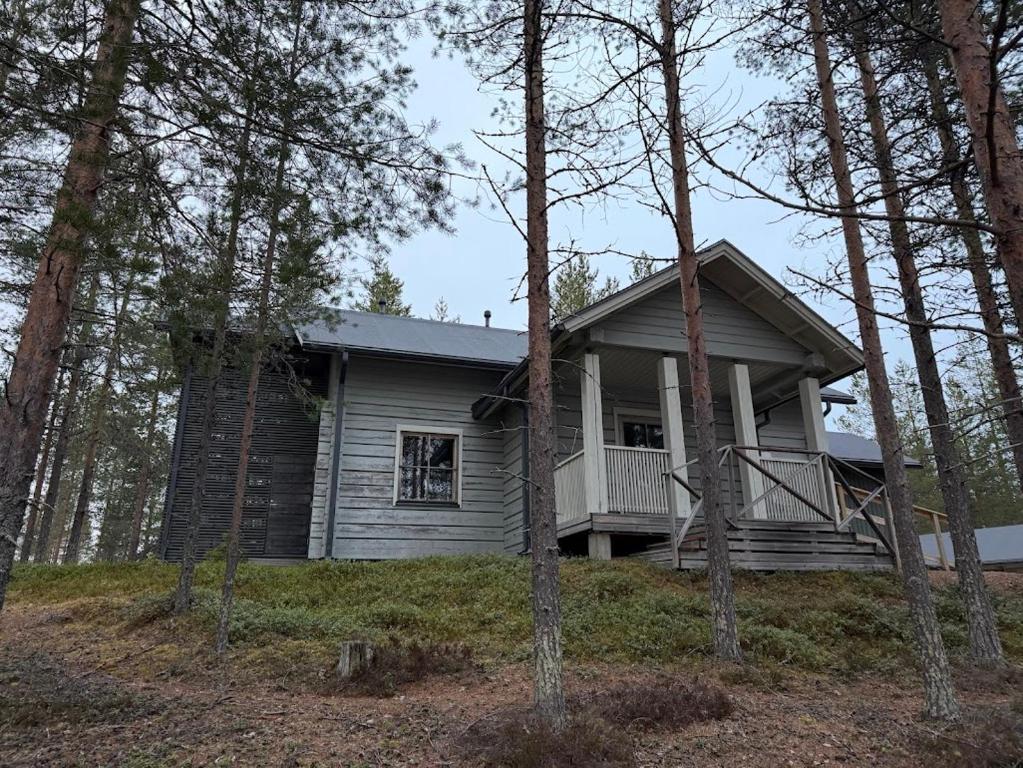 a small house on a hill in the woods at Pitkälampi Private Lake Lodge in Jokikylä