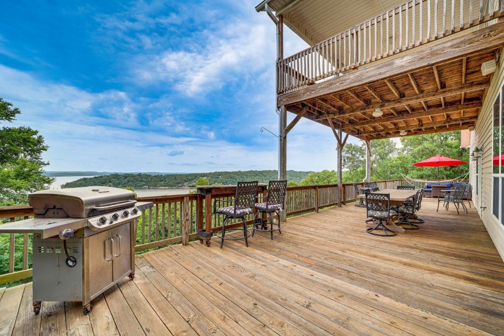 an outdoor deck with a grill and a table and chairs at Sunset View Deck! Lake Eufaula Family Getaway in Stigler