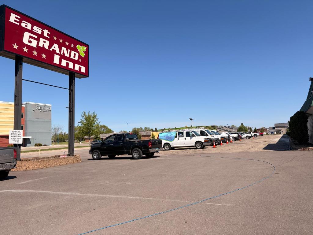 a parking lot with a sign for a grand inn at East Grand Inn Grand Forks ND I 29 in East Grand Forks
