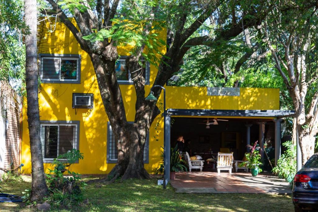 a yellow house with a tree in front of it at Casa Paso de la Patria in Corrientes
