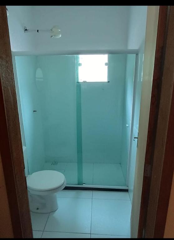 a bathroom with a toilet and a glass shower at Casa Areal in Araruama