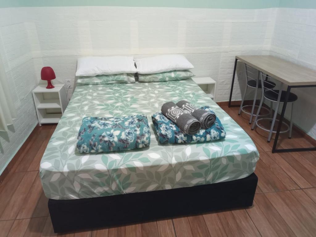 a bed with two pillows on it in a room at Suíte GiGá 2 in Brotas