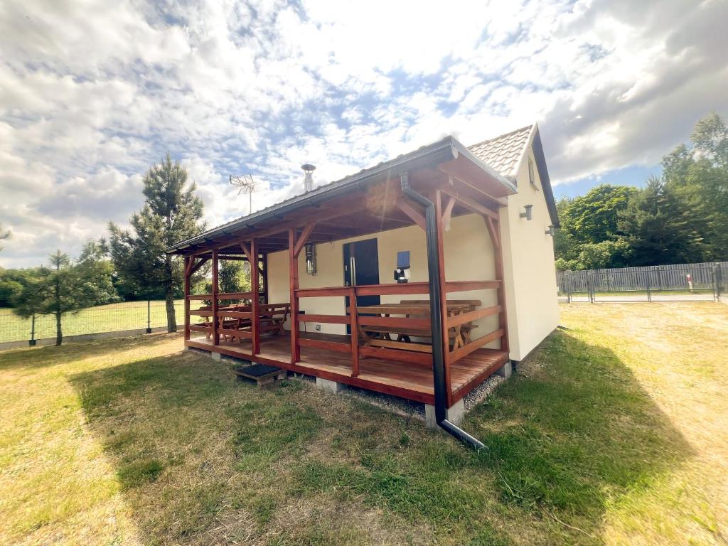 a small building with a roof on a grass field at Zieleniec in Drawsko