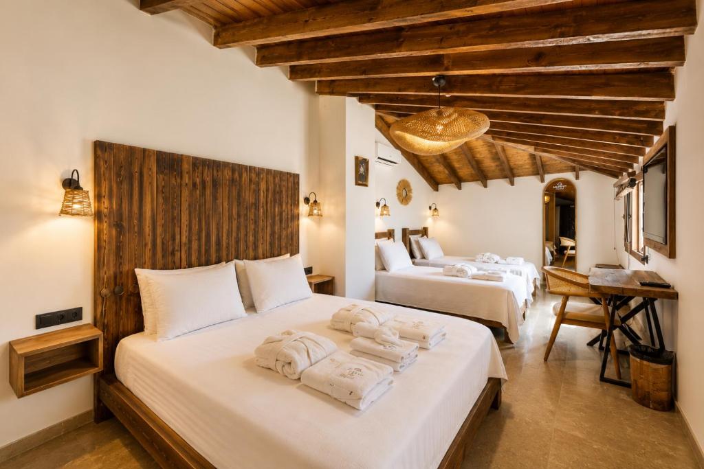 two beds in a room with wooden ceilings at NURİYE ALACATI in Alaçatı
