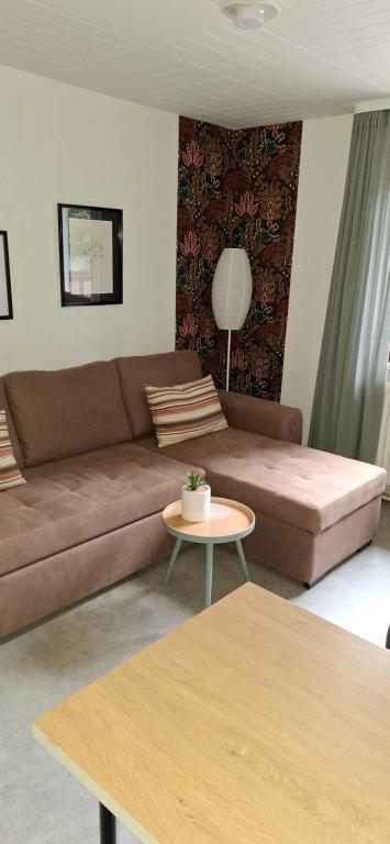 a living room with a brown couch and a table at Hochwald appartement in Bad Sachsa
