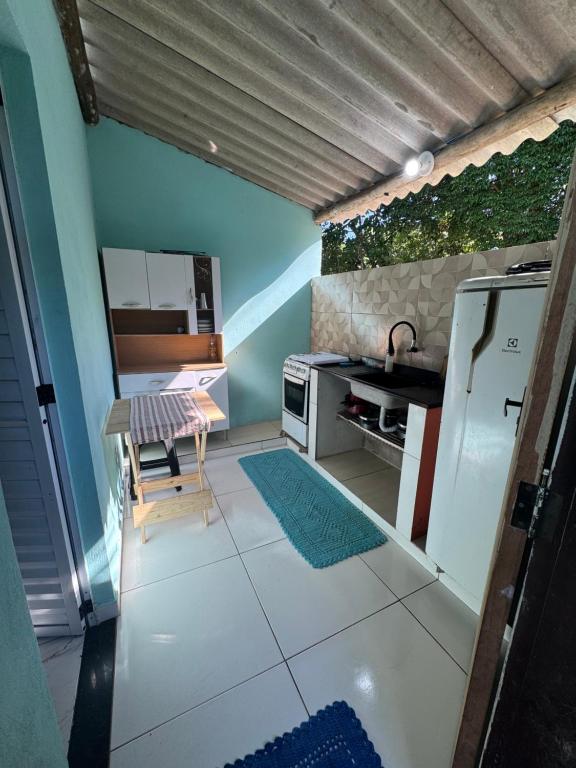 a small kitchen with a table and a refrigerator at Chalé in Paraty