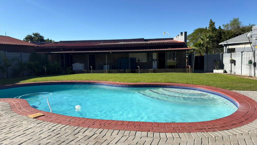 a swimming pool in a yard with a house at Polokwane Luxury Guest House in Polokwane