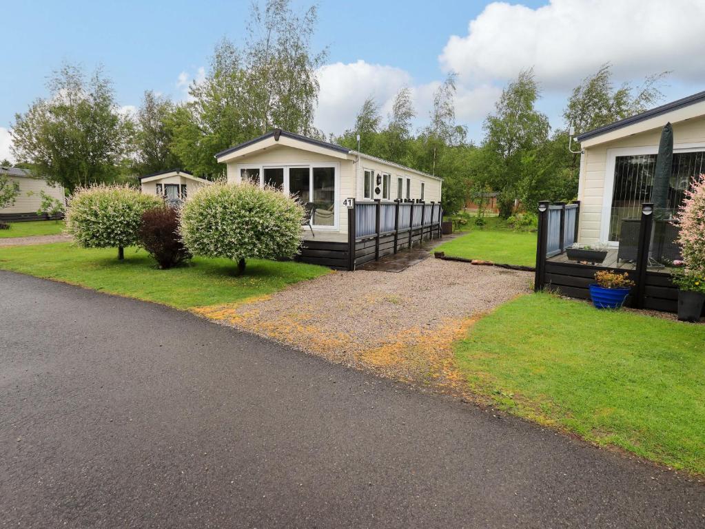 a small white house with a fence in a yard at 41, Grandma's Cottage in Carnforth