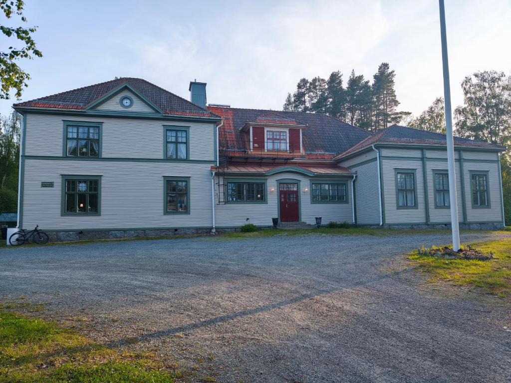 a large white house with a red door at Skärvsta gamla skola in Sollefteå