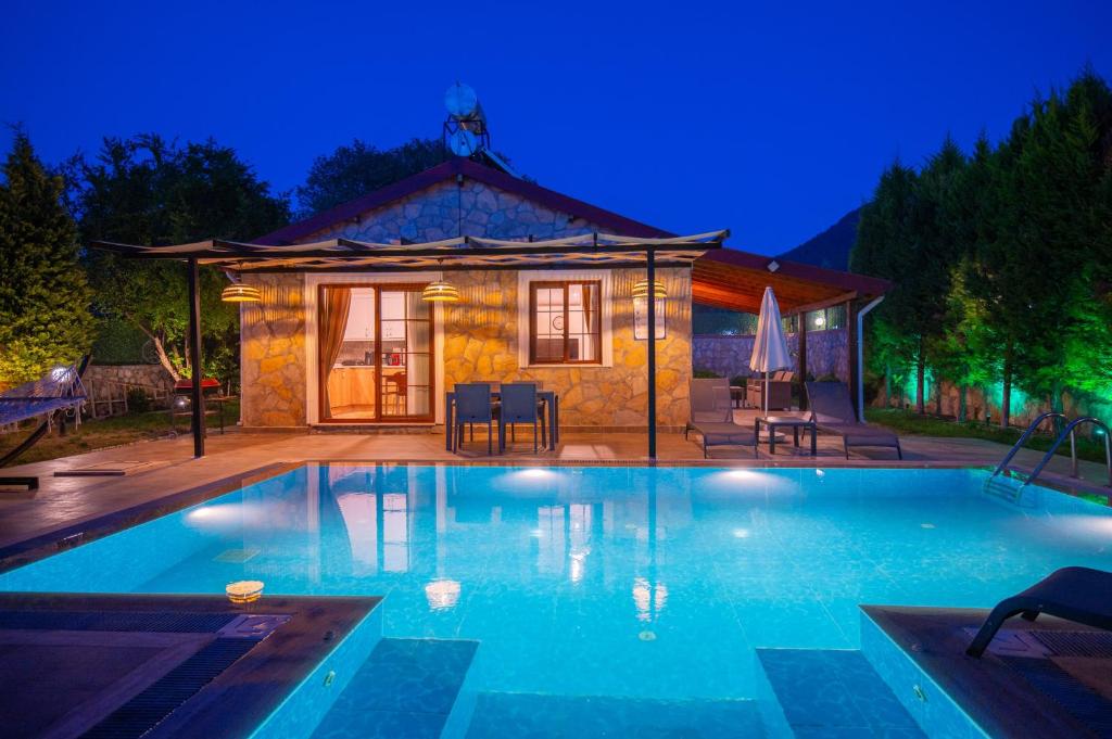 a swimming pool in front of a house at Villa Masal in Kayakoy