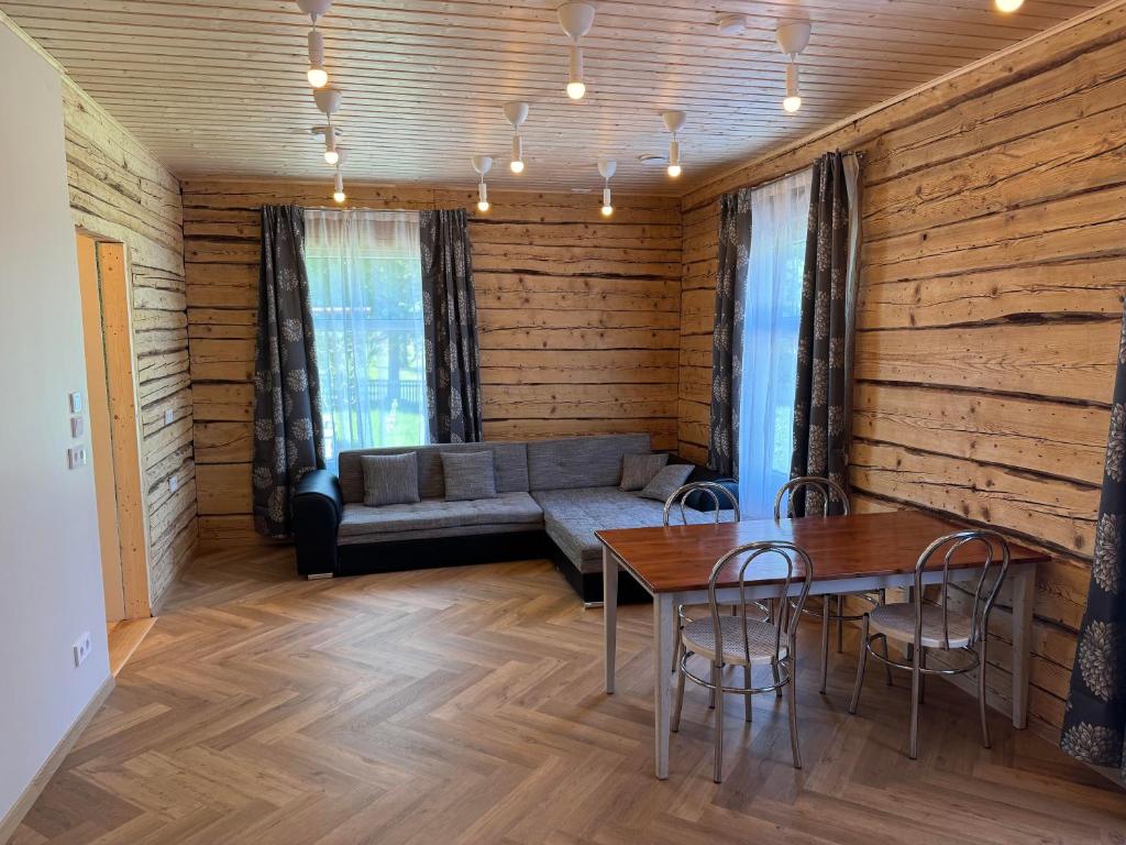 a living room with a couch and a table and chairs at ZenTen Apartment in Elva