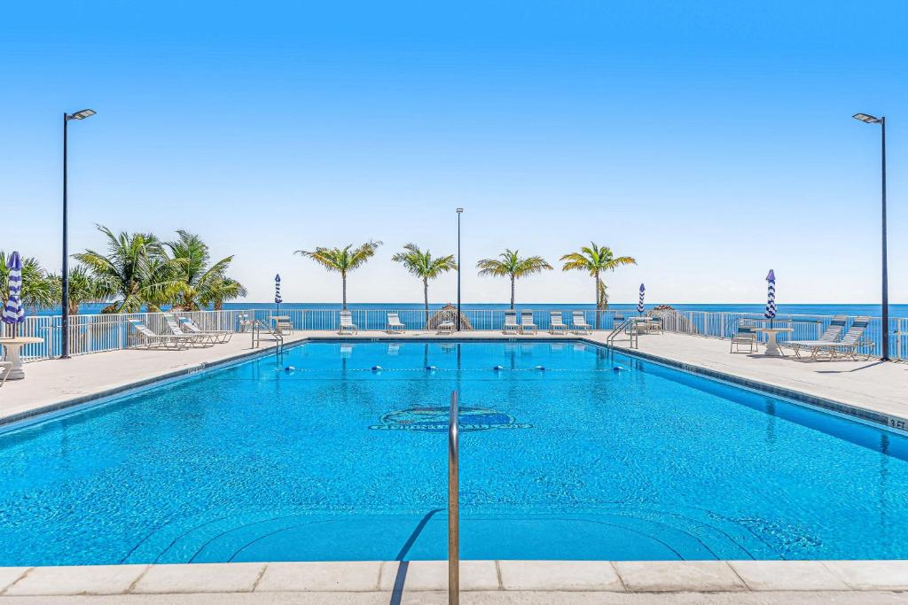 a swimming pool with the ocean in the background at Snowbird-friendly condo in oceanfront complex with heated pool, BBQ, AC in Marathon