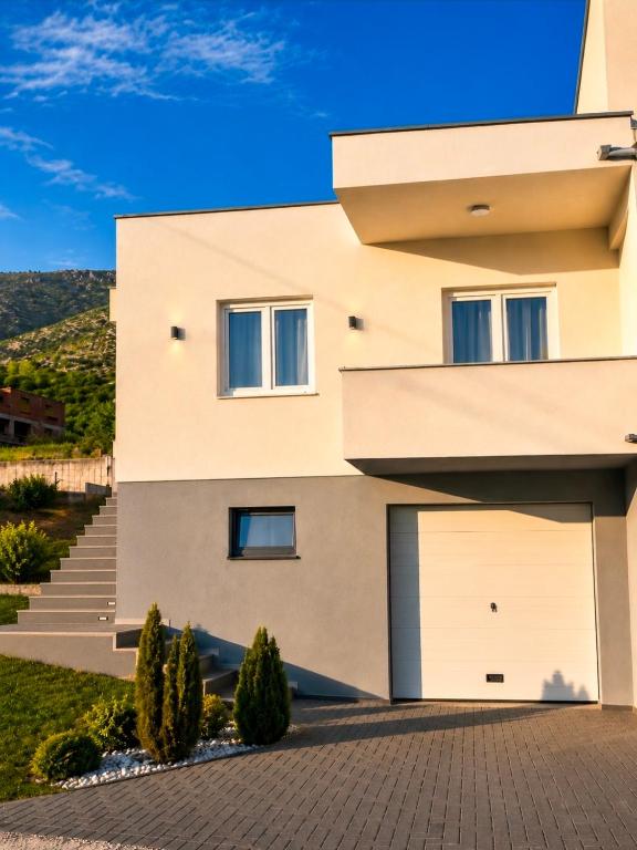 a building with two garage doors and trees at Apartment Arma in Mostar