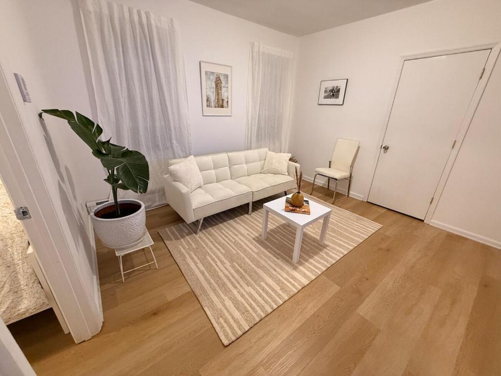 a living room with a white couch and a table at Spacious 2BR Getaway Easy Access to NYC & Newark in Kearny
