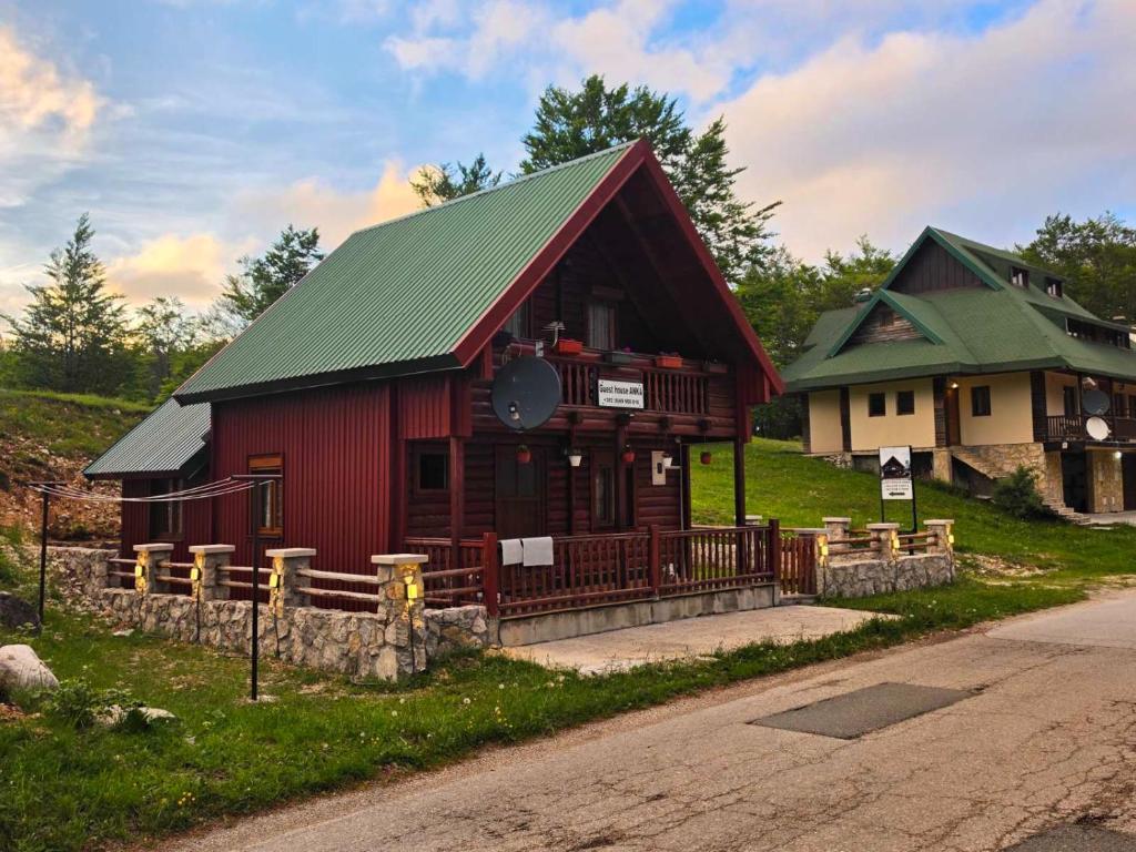 a small red building with a green roof at Guest house Anka in Žabljak