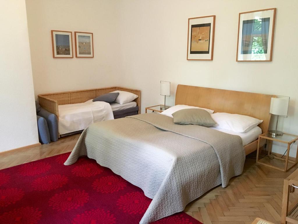 a bedroom with two beds and a red rug at Hotel Wiener Kindl in Vienna