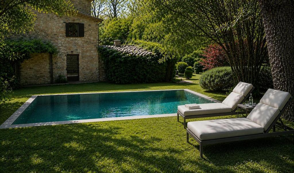 a swimming pool with two lounge chairs next to it at Casale Montone , villa with private pool in Montone