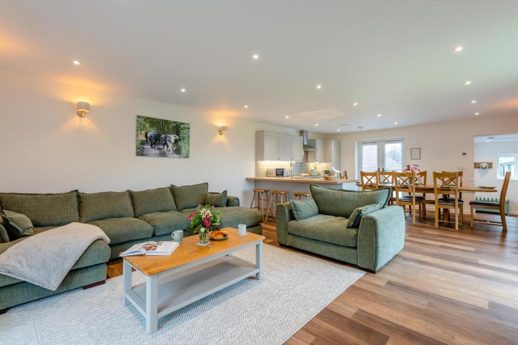 a living room with two green couches and a table at 4 Bed in Otterden oc-d36009 in Otterden