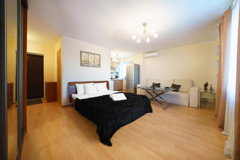 a bedroom with a bed and a living room at PaulMarie Apartments on Parijskoi Kommuny in Gomel