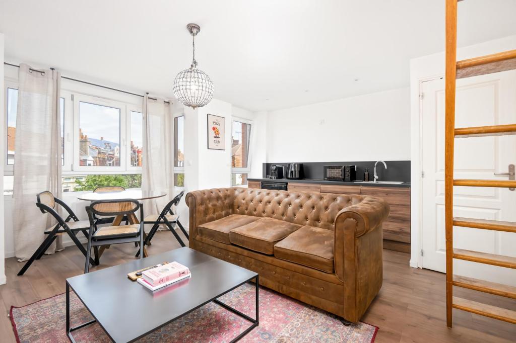 a living room with a couch and a table at Rockefeller - Le petit Loft New-Yorkais 5 Min de la plage in Dunkerque