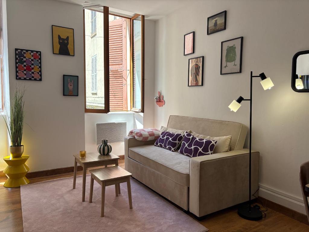 a living room with a couch and a table at L'Orelia - confortable T2 hyper centre in Montélimar