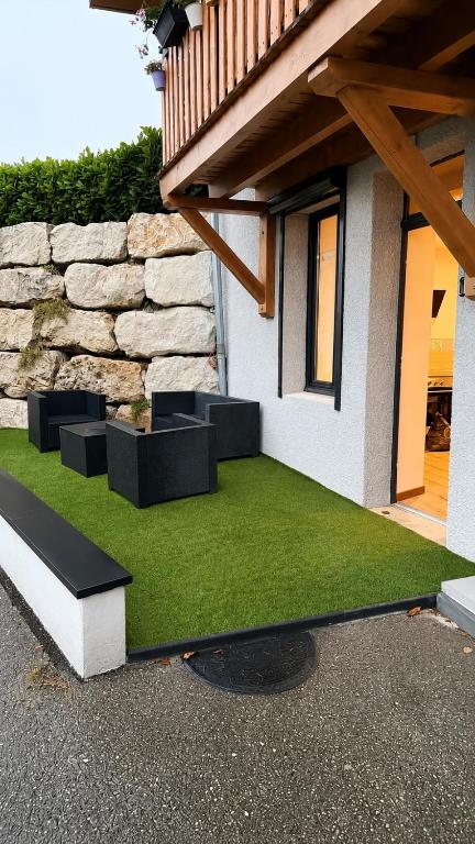 a patio with green grass next to a building at L Arcluzette in Fréterive