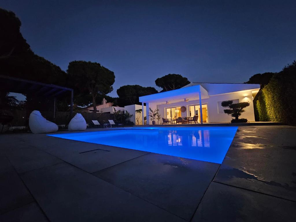 a villa with a swimming pool at night at Casa Robert in Conil de la Frontera