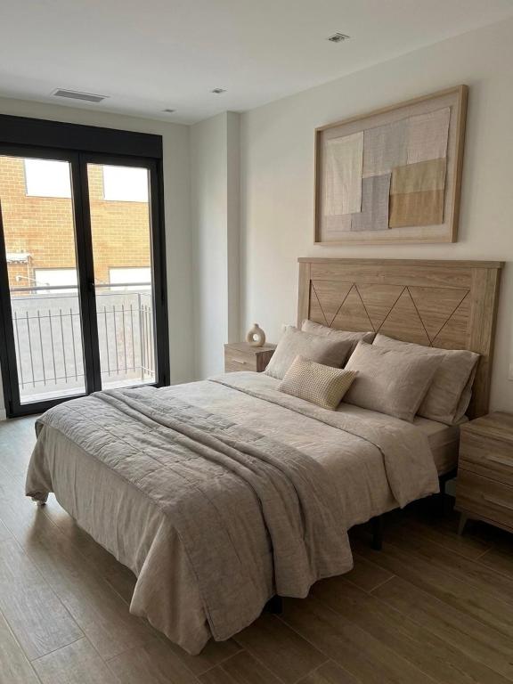 a bedroom with a large bed and a large window at Apartamento Mediodía 3 in La Bañeza