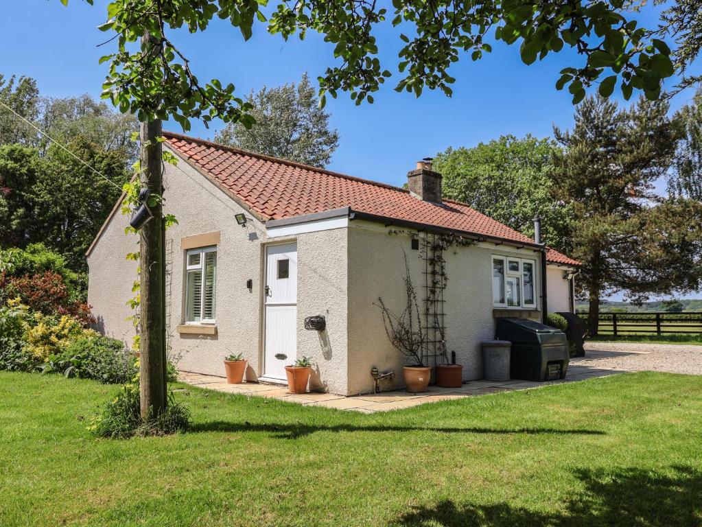 a small white cottage with a red roof at Low Grounds Cottage in York