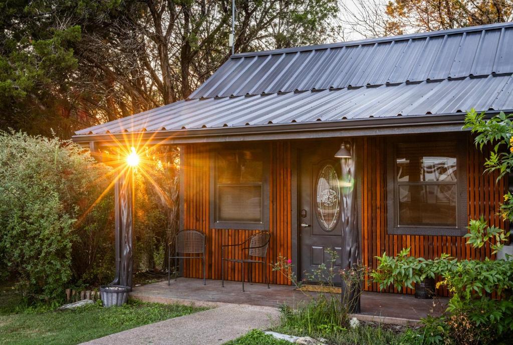 a small wooden house with a sun shining on it at Nicole Creek Cabins in Waco