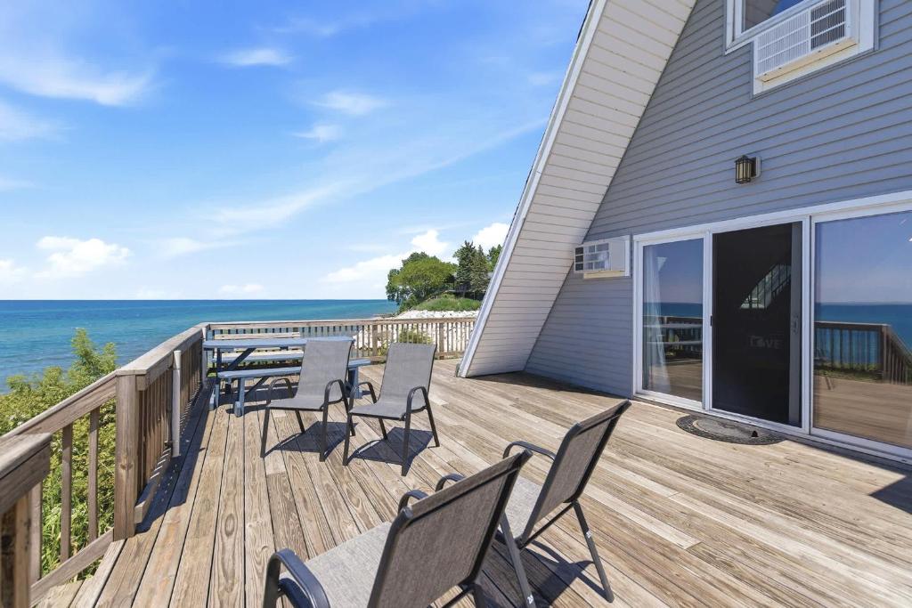 a deck with chairs and the ocean in the background at Chalet #20 in Stevensville