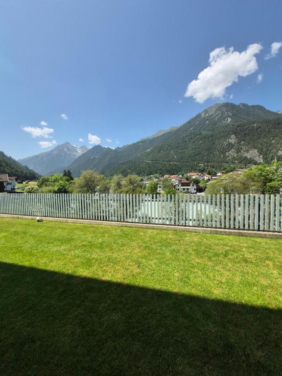 a fence in a yard with mountains in the background at Apart Bergluft in Pfunds